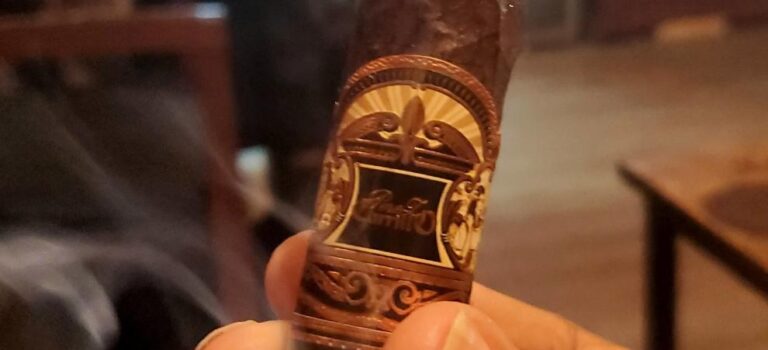 E.P. Carrillo Encore Black cigar being enjoyed inside a cigar lounge, highlighting the relaxing atmosphere and cigar lifestyle experience.